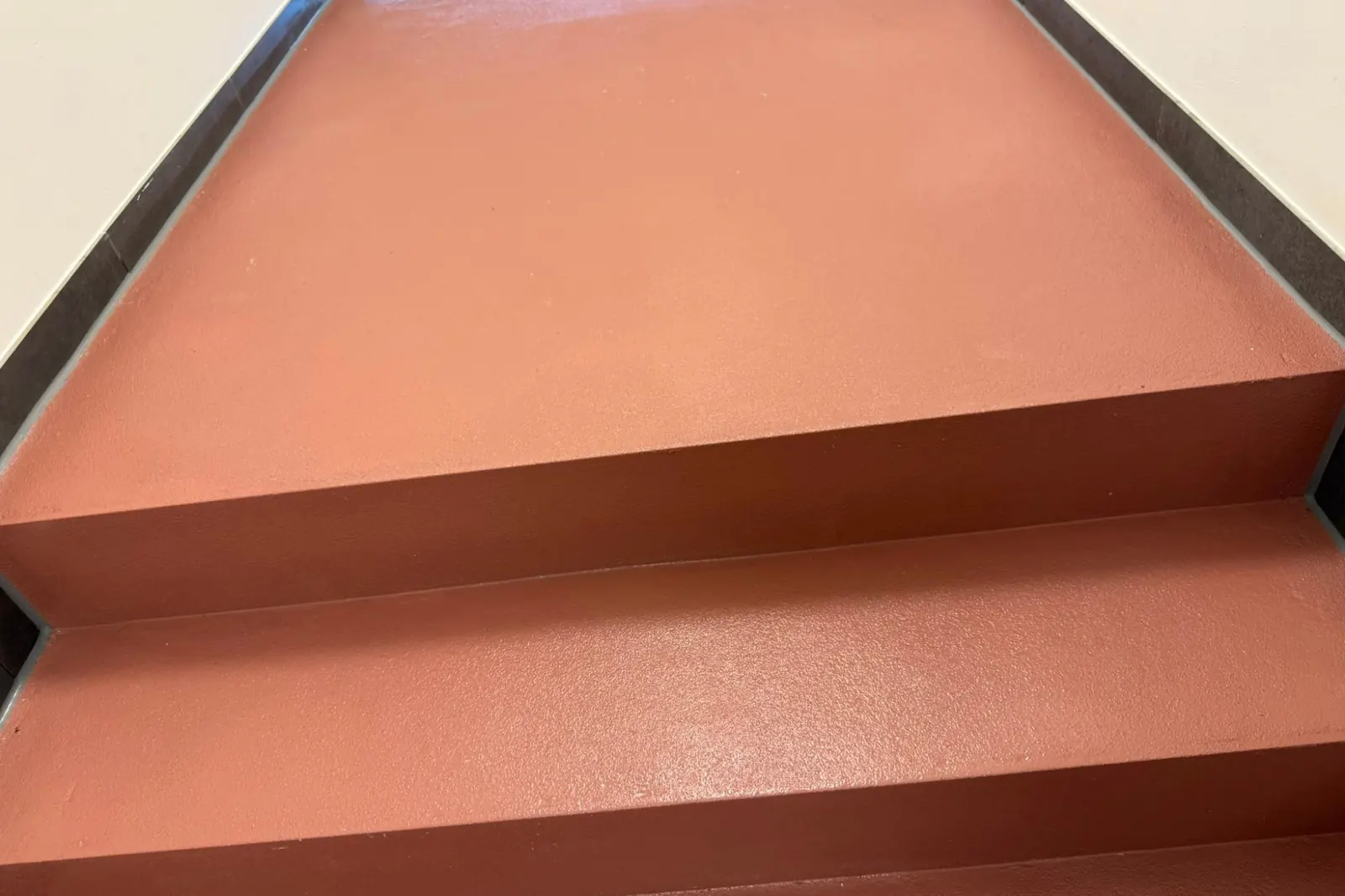 Frisch gereinigter roter Boden und Treppe im Eingangsbereich eines öffentlichen Gebäudes